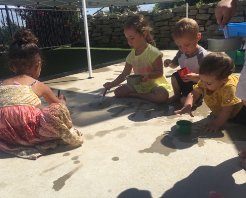 Waterpainting on warm day in Vista childcare